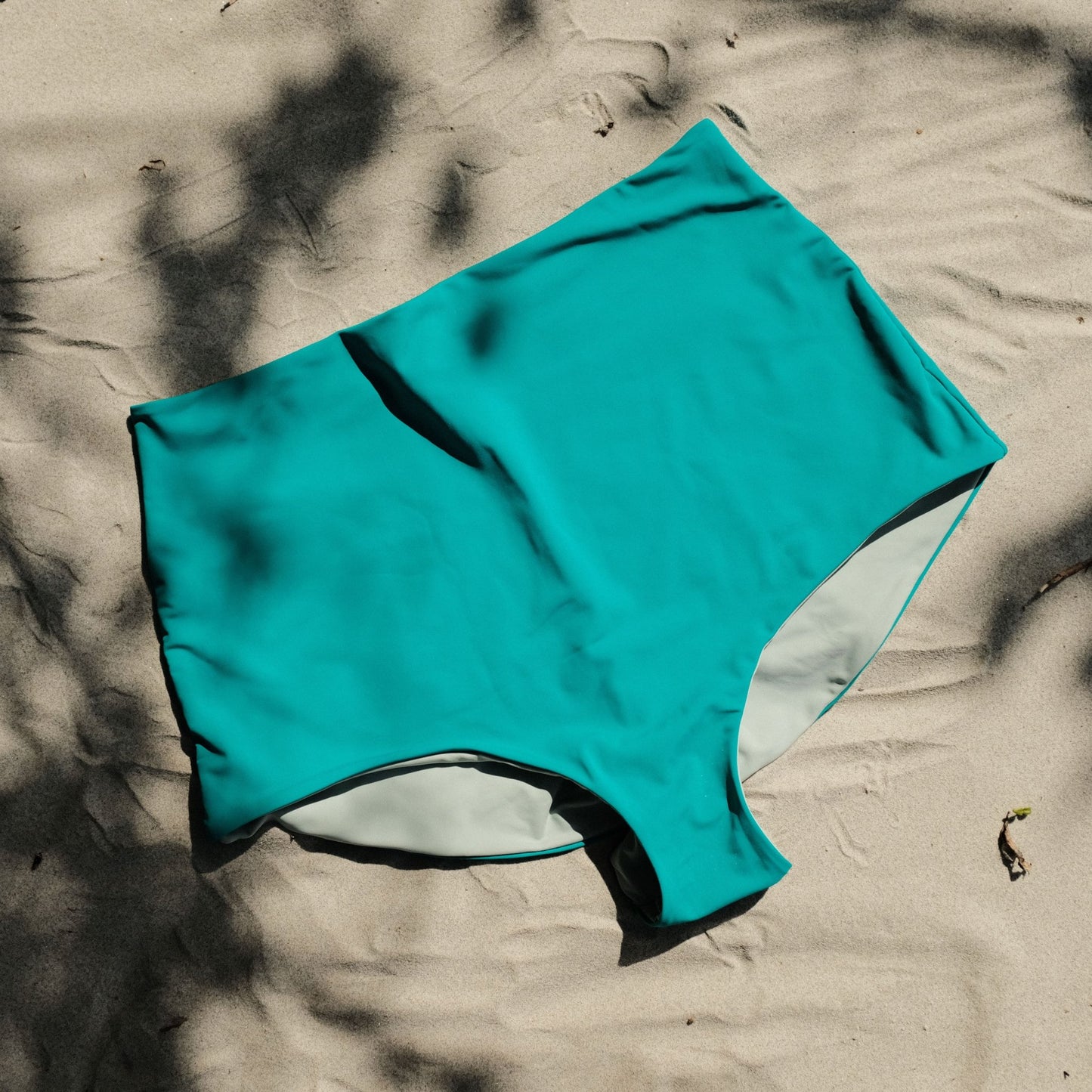 Pearl swim bottoms in Siren colour on sand