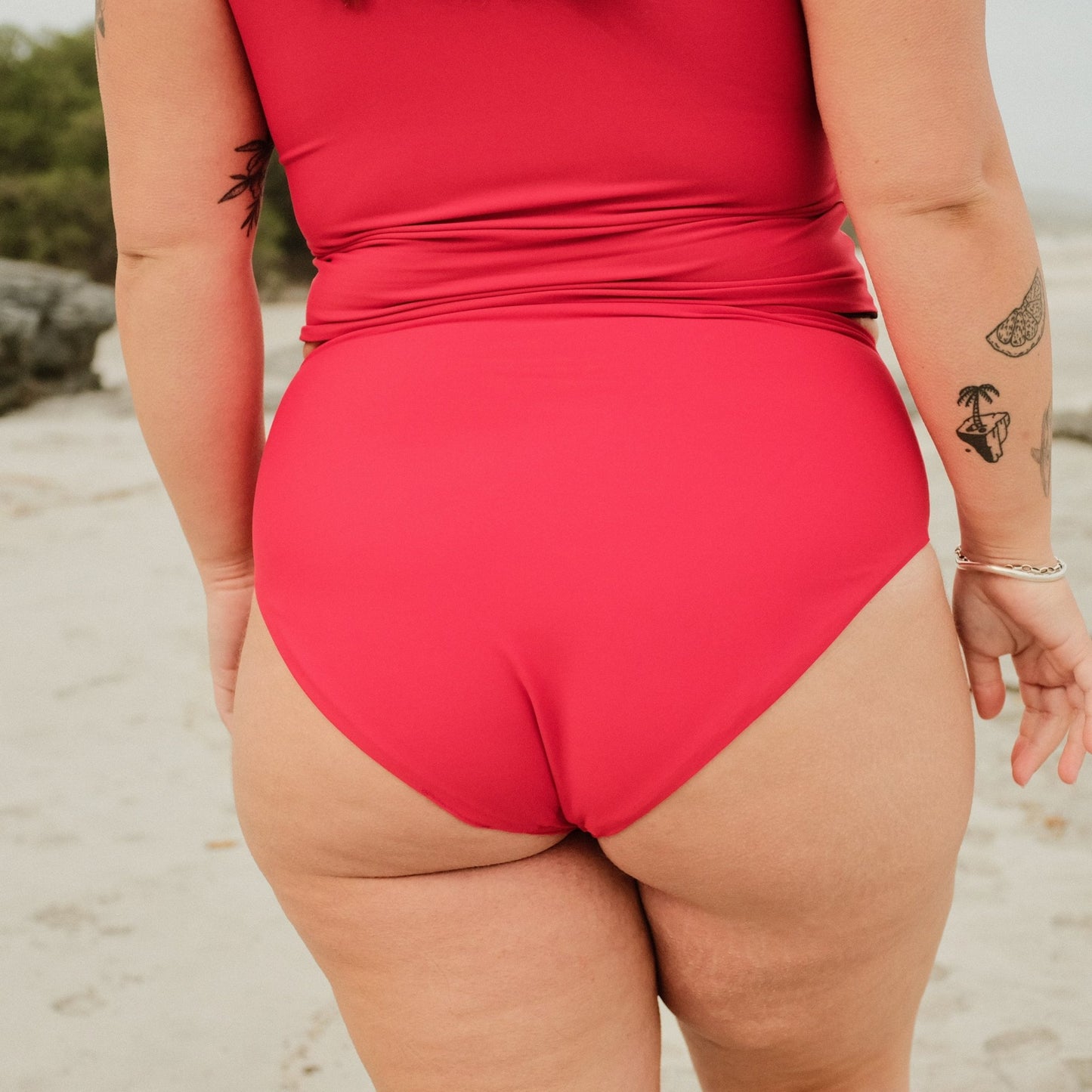 Woman wearing Peach swim bottoms in siren colour on beach