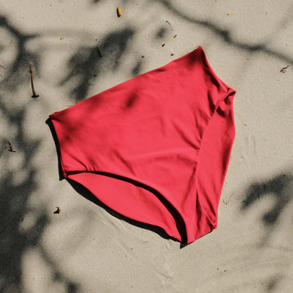 Peach swim bottom in Siren colour on sand